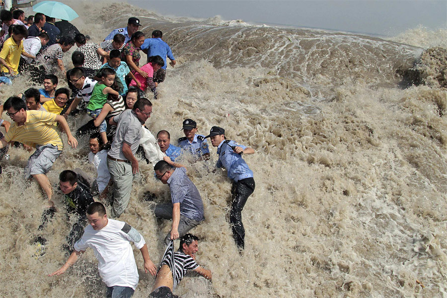 Местные жители спасаются от приливной волны на реке Цяньтан в городе Хайнин. © China Daily/Reuters