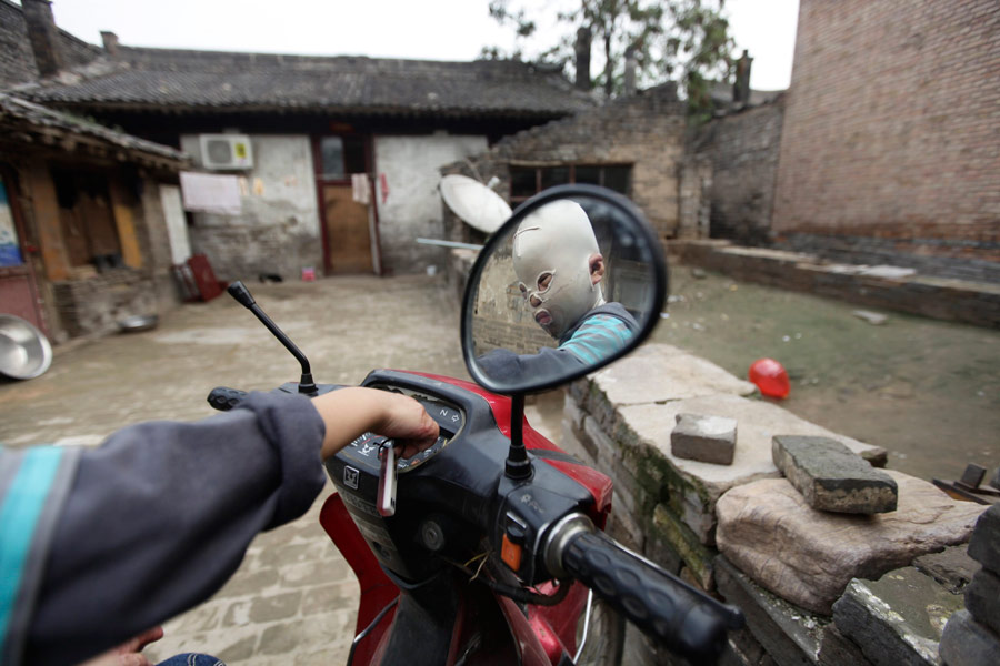 Китайский мальчик в маске. © Reuters / JASON LEE