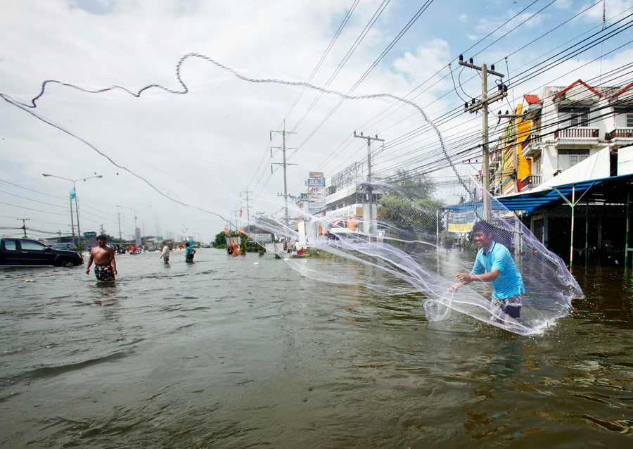 Мужчина ловит рыбу в затопленной провинции Аюттхая, Таиланд. © Chaiwat Subprasom/Reuters