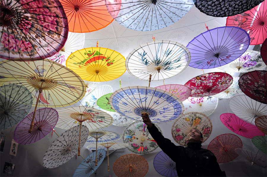 Продавец бумажных зонтиков на рынке в городе Сиань, Китай. © Rooney Chen/Reuters