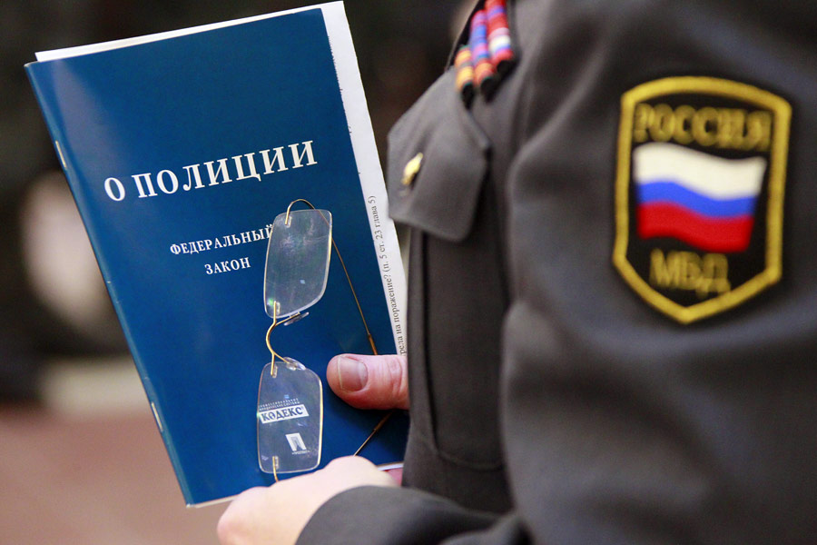 Сотрудник МВД с брошюрой «Закон о полиции». © Антон Денисов/РИА Новости