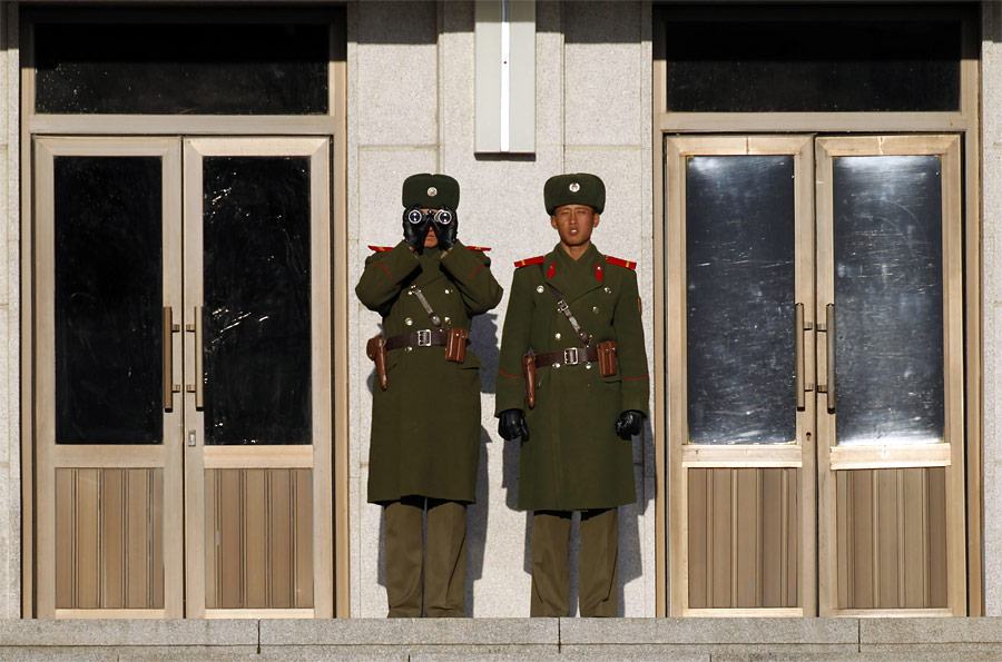 Северокорейские солдаты наблюдают за территорией Южной Кореи в демилитаризованной зоне между двумя странами в районе города Пхаджу. © Lee Jae-Won/Reuters