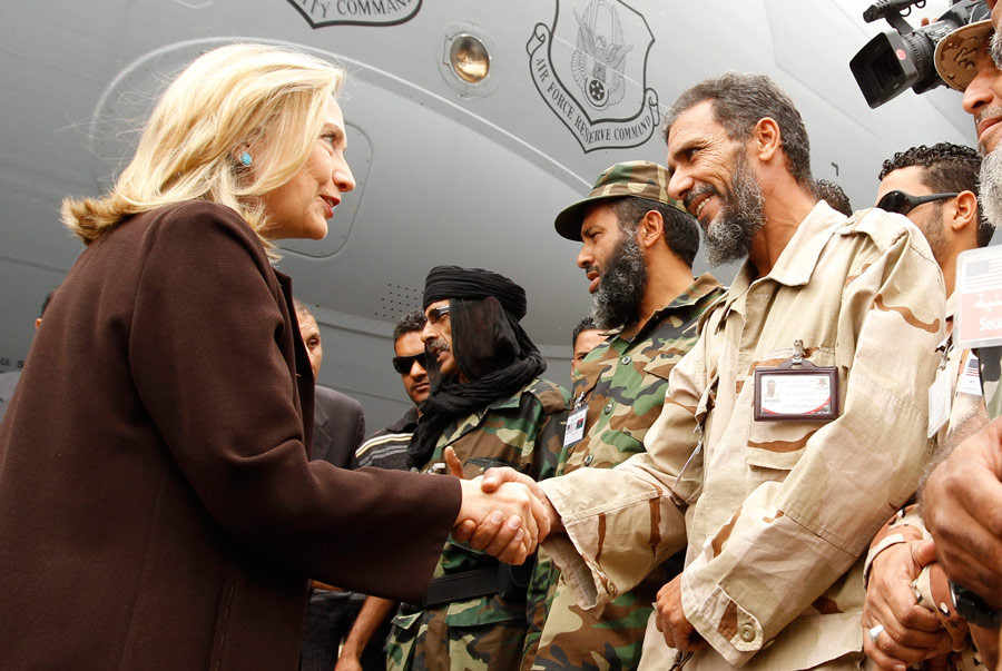 Госсекретаря США Хиллари Клинтон встречают ливийские солдаты у трапа самолета в Триполи. © Kevin Lamarque/Reuters