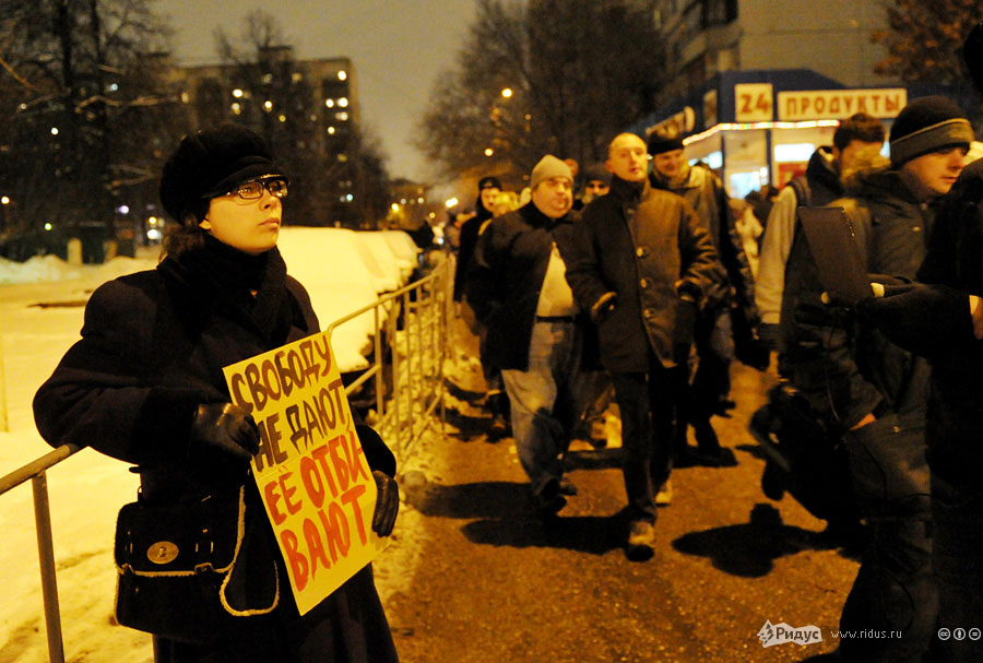 Задержанный участник встречи Удальцова с плакатом. © Антон Тушин/Ридус
