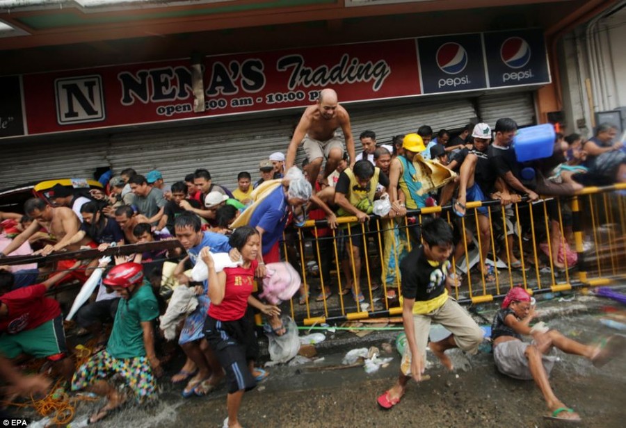 Dozens of people crowd outside a store in Tacloban