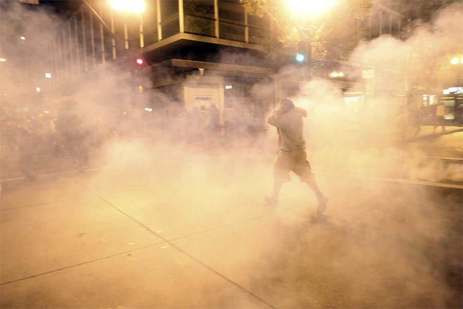 Участник акции Occupy Wall Street в Окленде убегает от слезоточивого газа. © Stephen Lam/Reuters