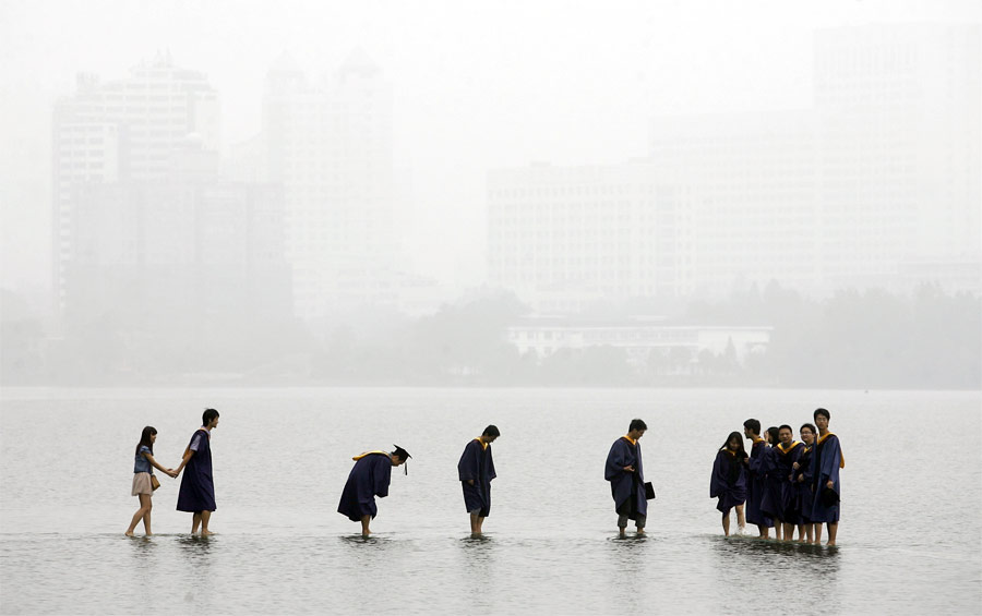 Китайские выпускники на затопленном мосту посреди озера в Ухане. © Darley Wong/Reuters
