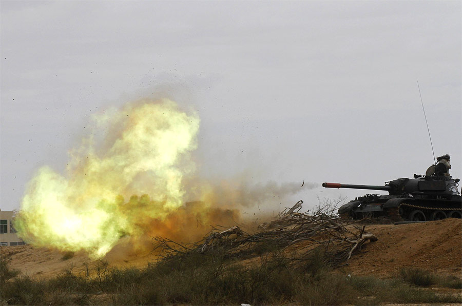 Танк Национального переходного совета Ливии стреляет по укреплениям в центре Сирта. © Anis Mili/Reuters
