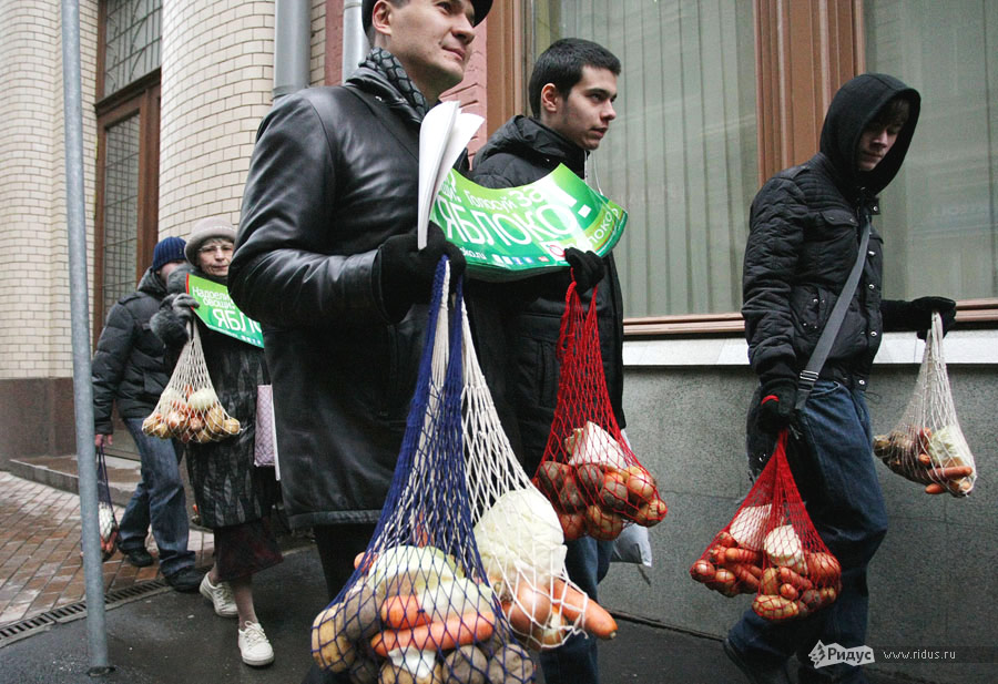 Активисты партии «Яблоко» несут сетки с овощами к зданию ЦИК РФ. © Антон Тушин/Ridus.ru