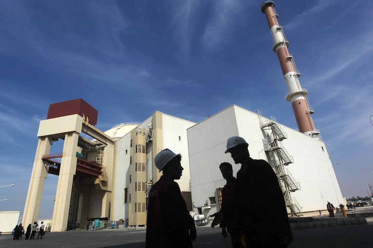 Иранские строители напротив здания Бушерской АЭС в Иране. © Reuters
