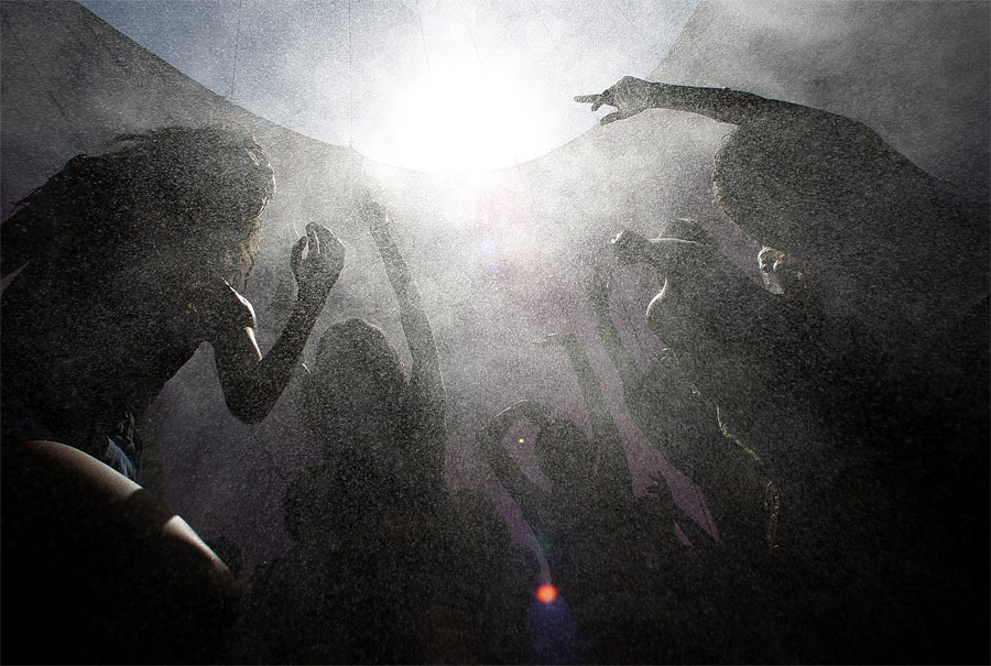 Посетители фестиваля Coachella в Калифорнии танцуют под брызгами холодной воды. © Mike Blake/Reuters