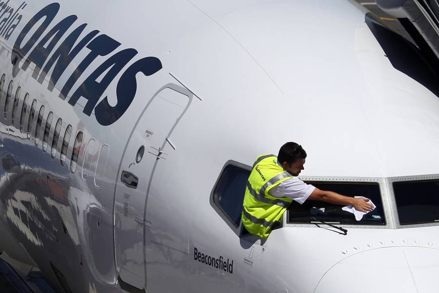Один из членов экипажа пассажирского авиалайнера австралийской компании Qantas Airways протирает слекло кабины пилотов. 13 февраля 2012 года в аэропорту Аделаиды. Фото Tim Wimborne/REUTERS