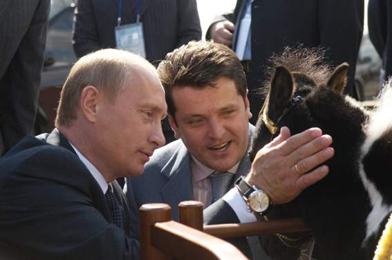 В.Путин демонстрирует чорной лошадке по имени Вадик свои дорогие часы.Обратите внимание, что колёсико часов в таком положении ни сколько ни натирает руку.