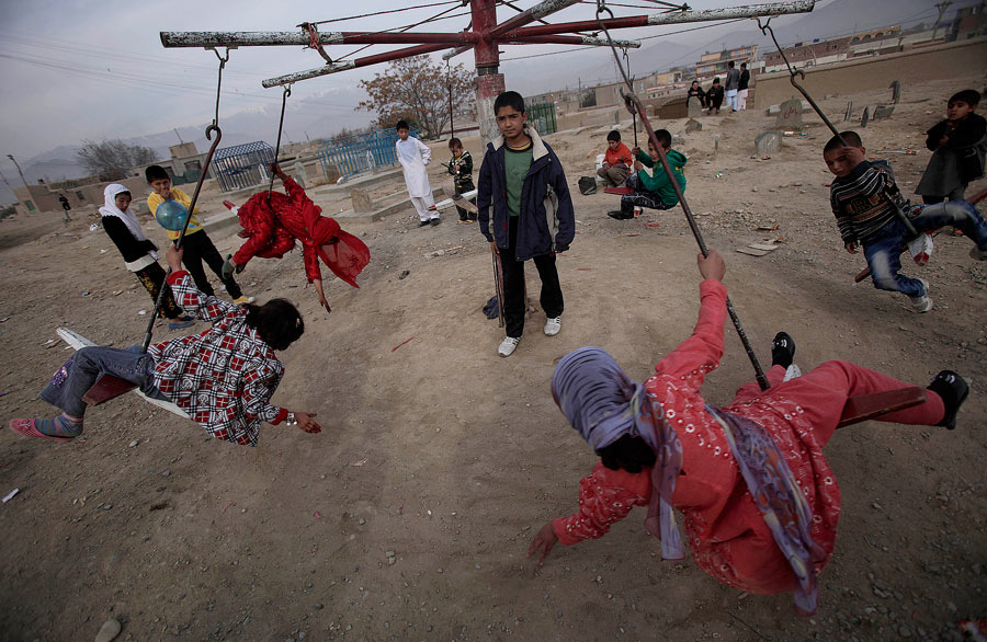 Афганские дети катаются на карусели в Кабуле. © Muhammed Muheisen/AP Photo