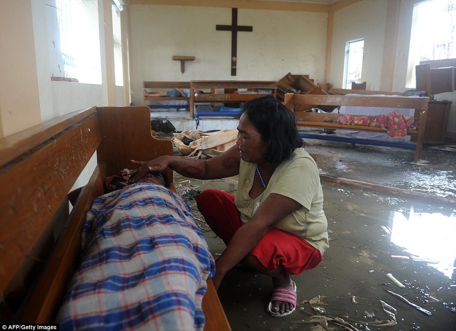 Loss: A mother weeps beside the dead body of her son at a chapel in the aftermath of Typhoon Haiyan in Tacloban