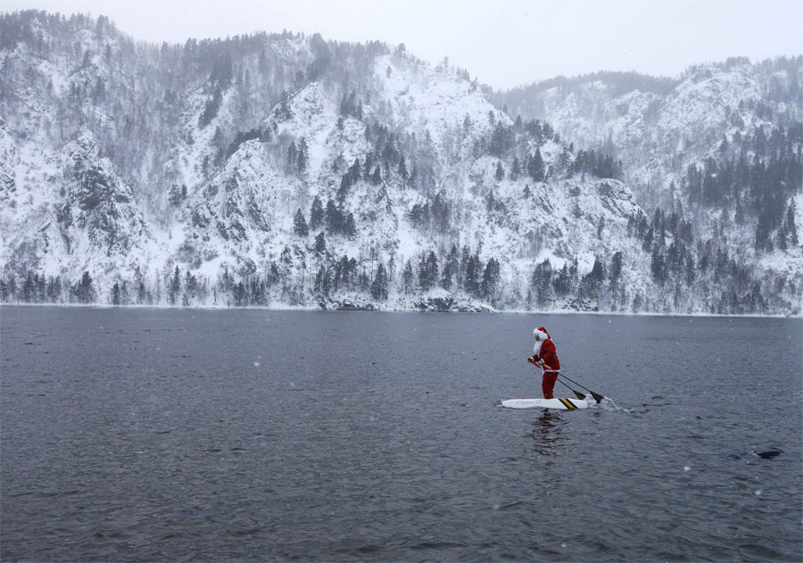 Красноярский учитель Николай Васильев, сконструировавший уникальные водные лыжи, идет на них по Енисею в костюме Деда Мороза. © Илья Наймушин/Reuters