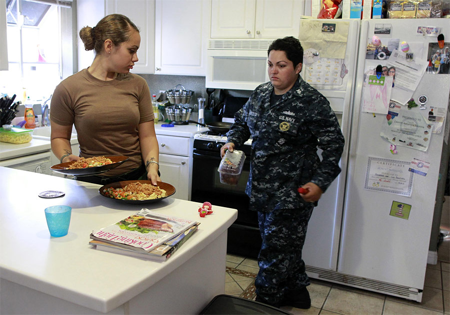 Советник 1-го класса ВМС США Лус Батиста готовит ужин со своей невестой, старшиной 2-й статьи ВМС США Алехандрой Шварц. © Lucy Nicholson/Reuters