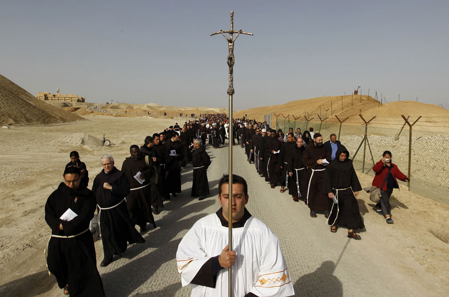 Католические пилигримы идут за церковным шествием от монастыря Святого Иоанна к Каср-эль-Яхуд на берегу реки Иордан, традиционно считающемуся местом крещения Иисуса Христа. © AMMAR AWAD/Reuters