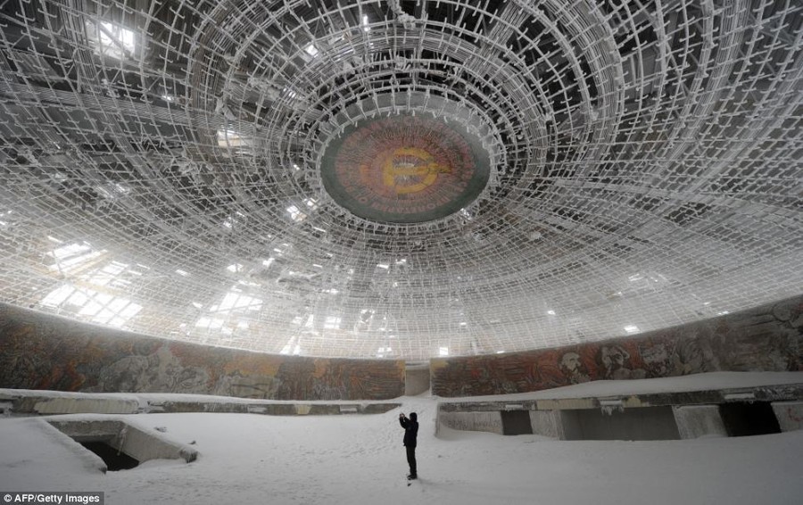 A lone man takes pictures inside the crumbling House of the Bulgarian Communist Party on Mount Buzludzha, no longer needed after the party has lost its grip on the country