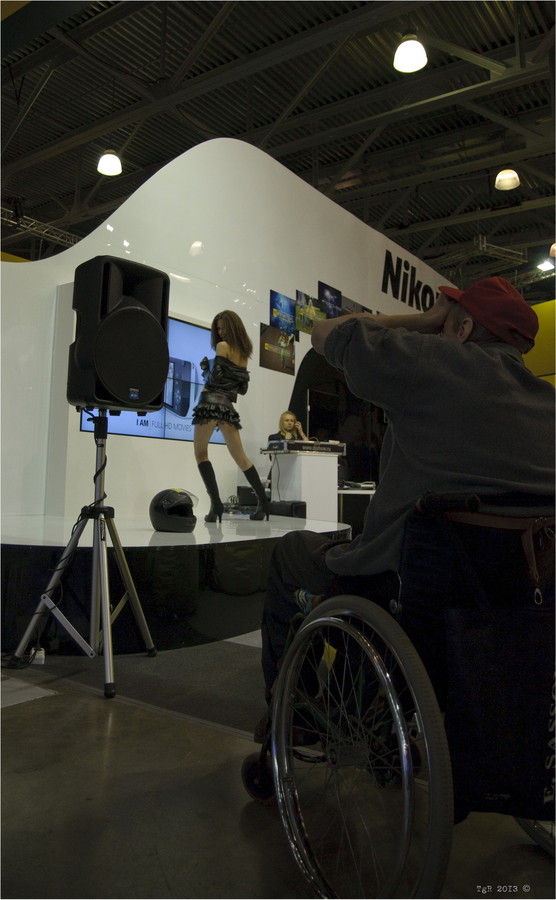 Фотограф на инвалидной коляске фотографирует модель на стенде Nikon