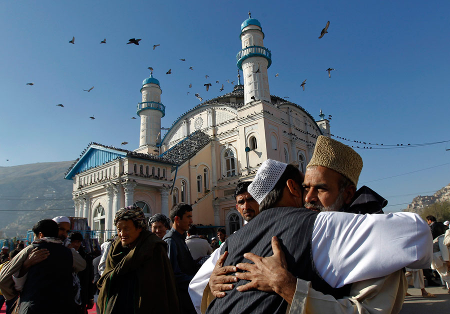 Афганские мужчины приветствуют друг друга у входа в мечеть в Кабуле. © Omar Sobhani/Reuters