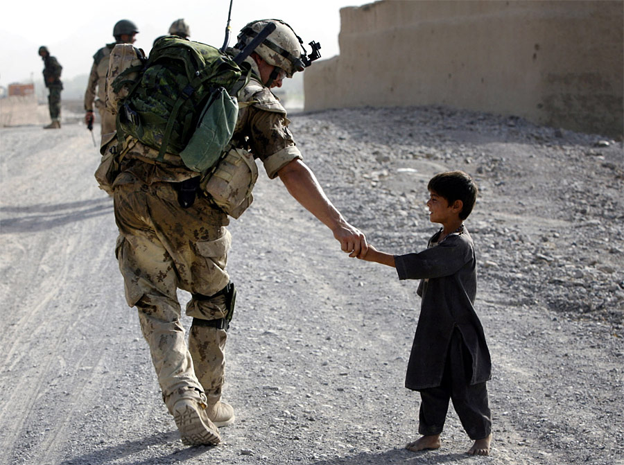 Канадский солдат здоровается с маленьким афганцем во время патрулирования у деревни Панджваи. © Finbarr O'Reilly/Reuters