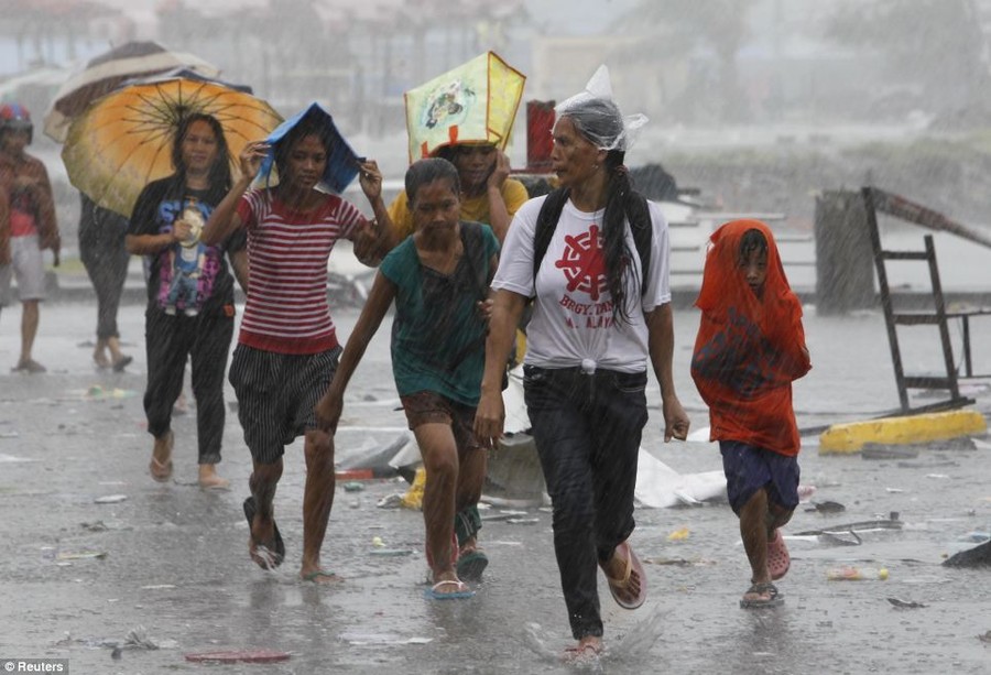 Survivors walk towards the evacuation center to get relief goods after super Typhoon Haiyan battered Tacloban city, central Philippines 