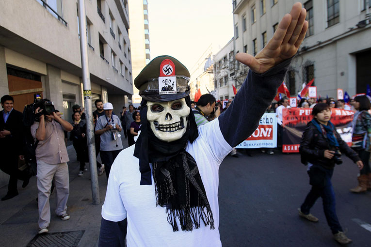 В годовщину военного переворота демонстранты протестуют против министра внутренних дел Чили Хинцпетера. © IVAN ALVARADO/Reuters