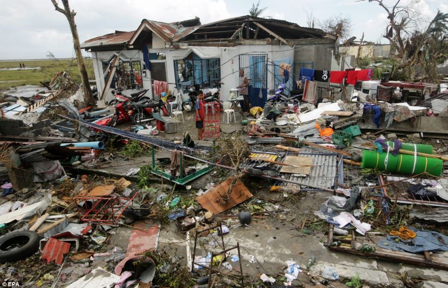 Flattened: A Filipino boy stands among the debris in Tacloban, Leyte province - one of the worst hit areas of Typhoon Haiyan