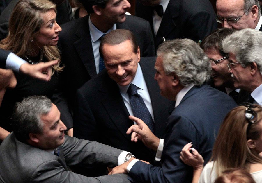 Премьер-министр Италии Сильвио Берлускони (в центре) в окружении членов Парламента. © Alessandro Bianchi/Reuters