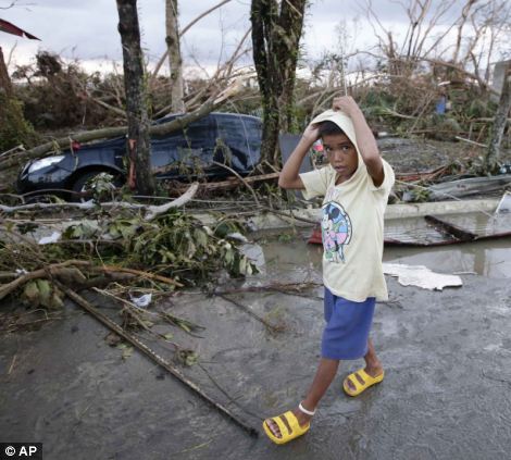 A boy walks past the devastation brought about by powerful typhoon Haiyan at Tacloban city