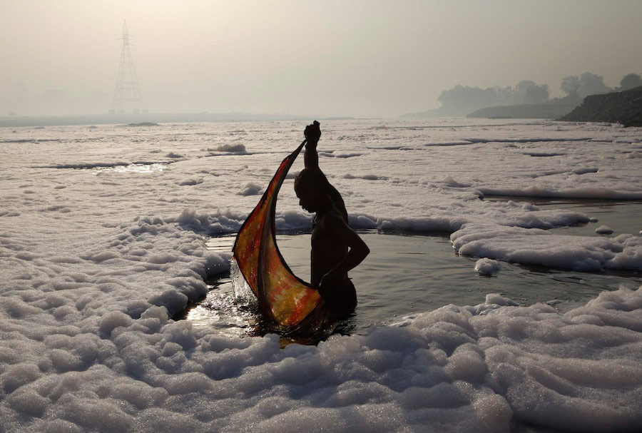 Индус после риатульного купания в загрязненной реке Ямуна в Нью Дели, окутывает себя одеждой. © Danish Siddiqui/Reuters