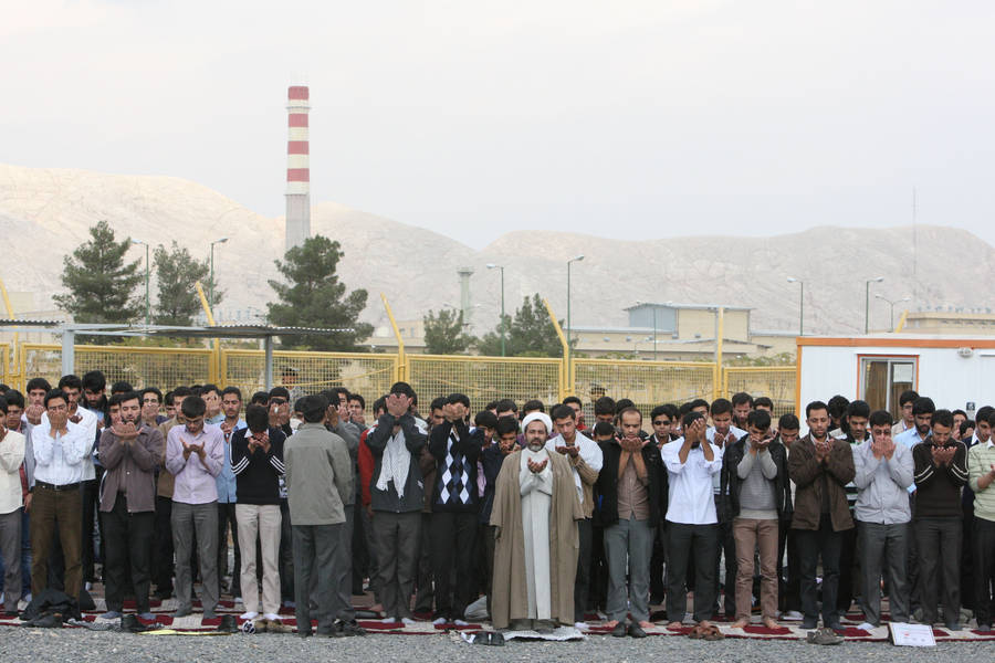Иранские студенты молятся перед зданием завода по обогащению урана. © Vahid Salemi/AP