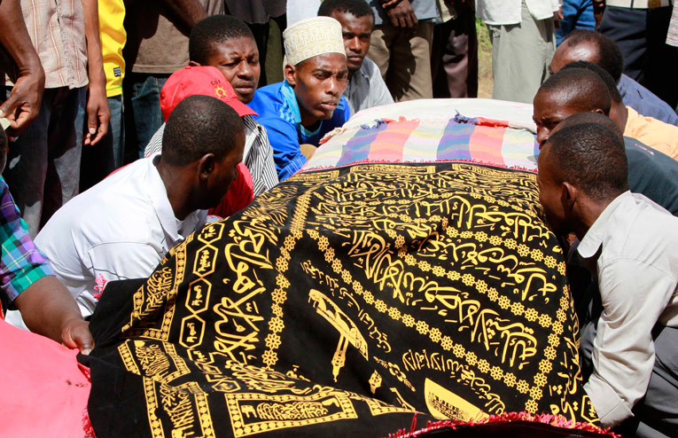 Родственники погибшего мужчины несут гроб с телом на захоронение. © Reuters / THOMAS MUKOYA