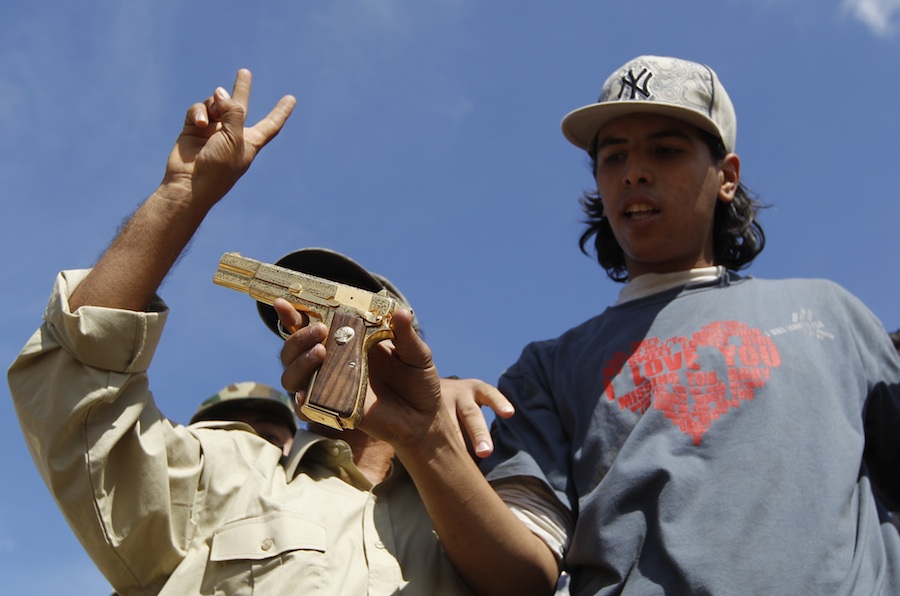 18-летний Ахмед Шайбани, убивший Муаммара Каддафи, с золотым пистолетом диктатора в руках. © Thaier al-Sudani/Reuters