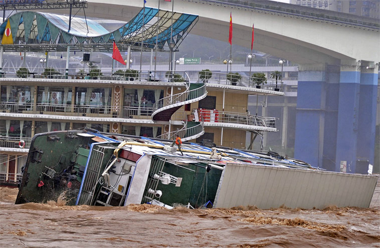 Из-за подъема уровня воды на реке Цзялинцзян в городе Чунцин перевернулся трехпалубный плавучий ресторан. © China Daily/Reuters