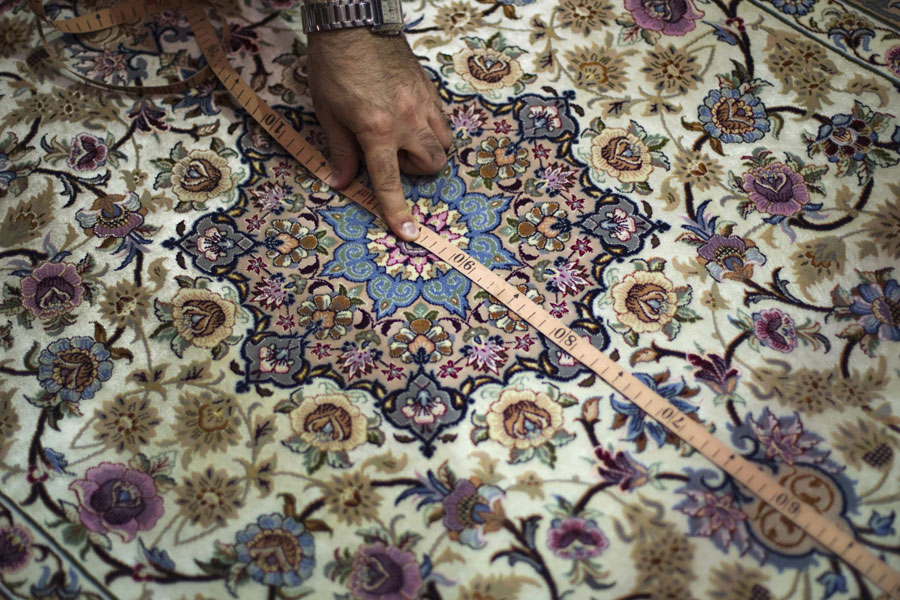 Артин Маркосян, профессор академии искусств Исфахана меряет ковер. © MORTEZA NIKOUBAZL/Reuters