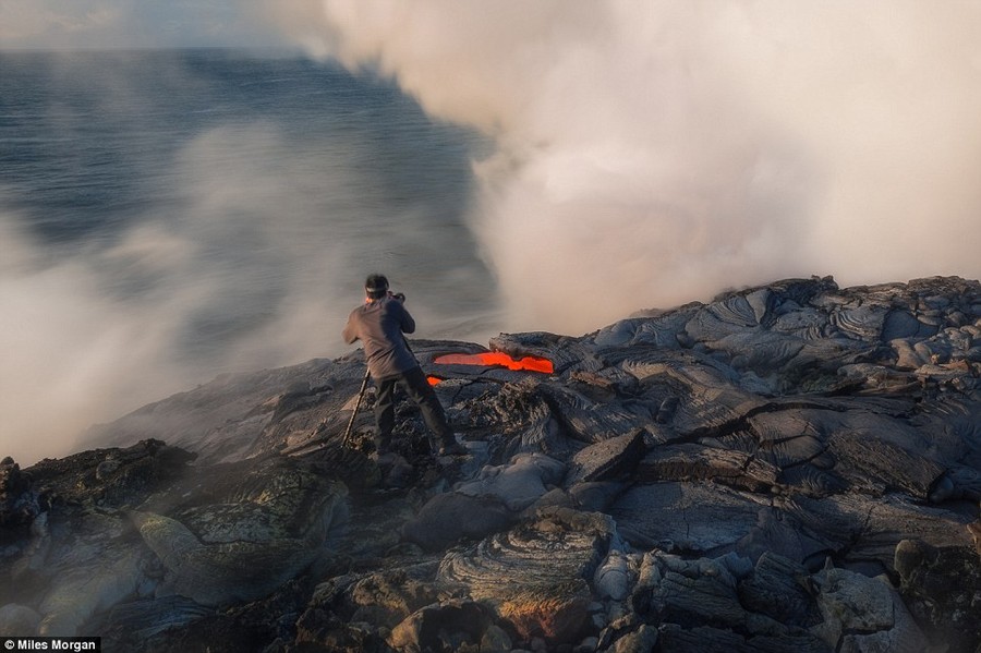 Close call: Bruce Omori inches up to a scalding river of lava. Before Bruce could get a frame off, and seconds after this picture was made, the entire delta to his left gave way, sending him scrambling back uphill 