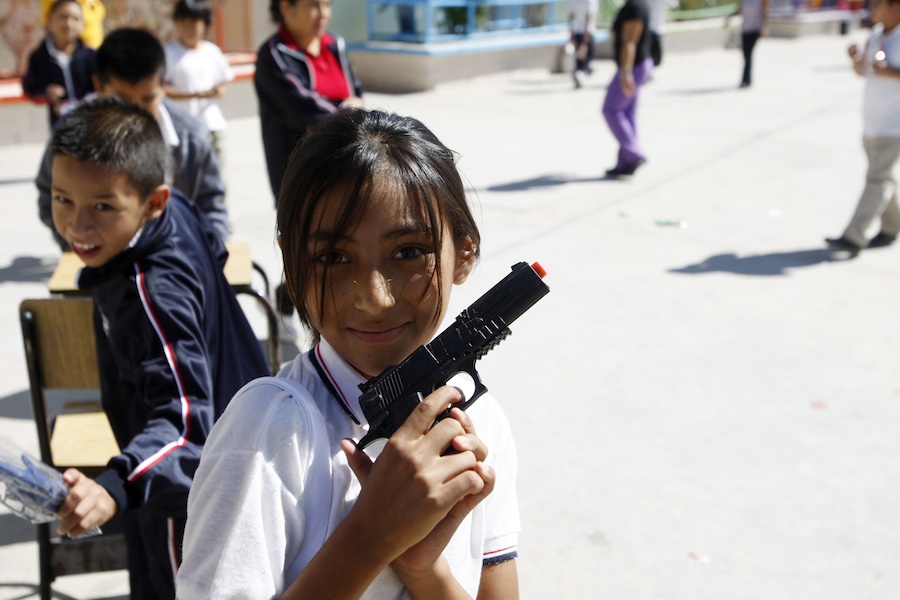 Школьница позирует с игрушечным пистолетом с городе Сьюдад-Хуарес, Мексика. © Jose Luis Gonzalez/Reuters