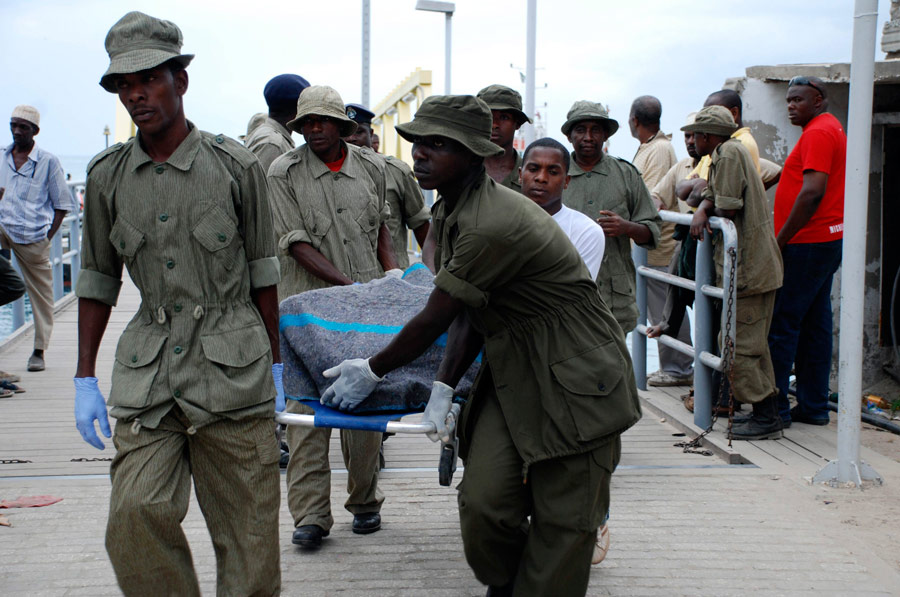 Полицейские переносят тела погибших при крушении парома. © Reuters / Emmanuel Kwitema