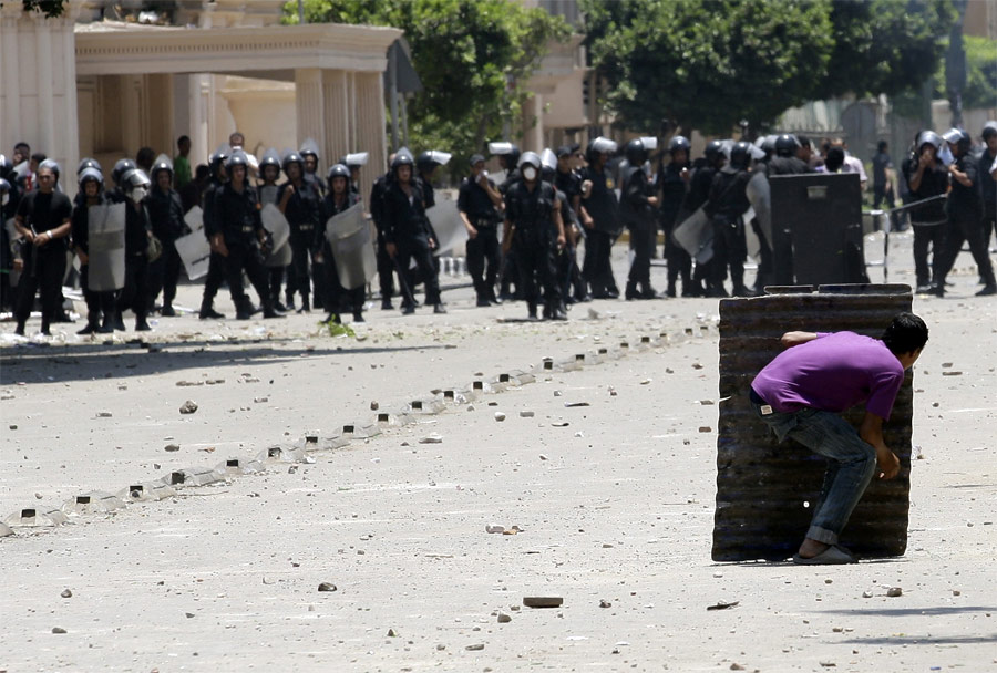 Демонстрант прячется от полиции во время столкновений в Каире. © Mohamed Abd El-Ghany/Reuters
