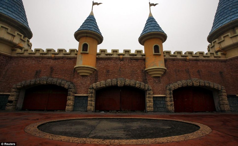 Boarded entrance gates now guard Wonderland in Beijing, which had once been promoted by developers as 'the largest amusement park in Asia'