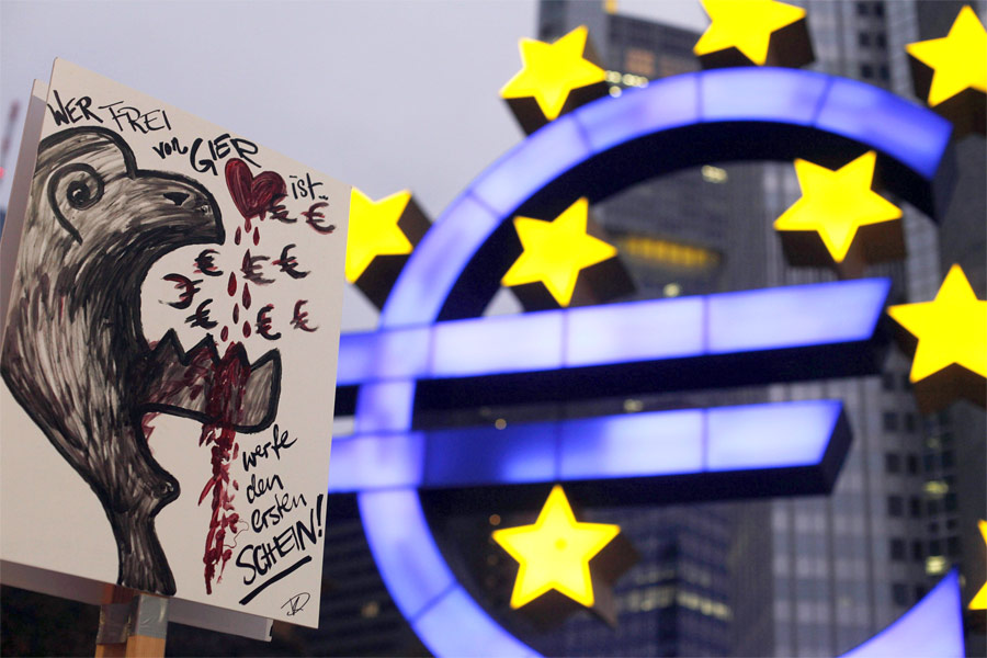 Плакат «Кто не жаден, пусть первый бросит камень» у здания Европейского центрального банка во Франкфурте. © Ralph Orlowski/Reuters