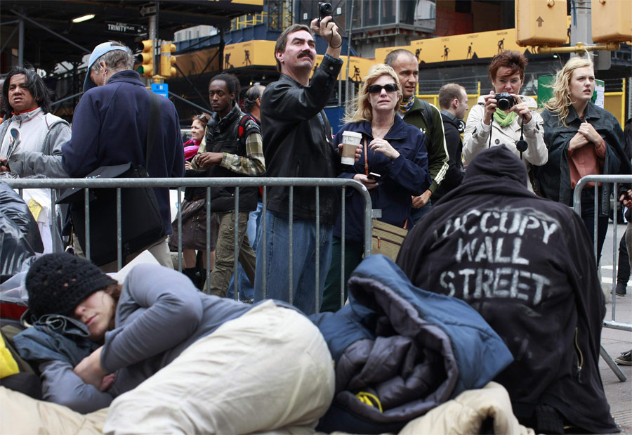 Туристы фотографируют участников акции Occupy Wall Street в Нью-Йорке. © Shannon Stapleton/Reuters