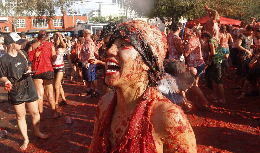 Женщина смеется во время томатной битвы в ходе проведения местной версии испанского фестиваля La Tomatina Tomato Fight Festival в Майами. © Andrew Innerarity/Reuters