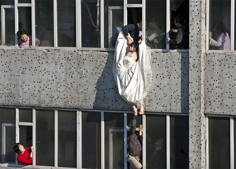 22-летнюю китаянку, пытавшуюся выброситься из окна из-за разрыва с женихом, спасли в последний момент. © China Daily/Reuters