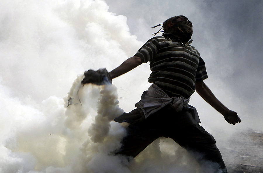 Египетский демонстрант кидает гранату со слезоточивым газом в полицейских, которые ранее кинули эту гранату в демонстрантов. © Amr Abdallah Dalsh/Reuters