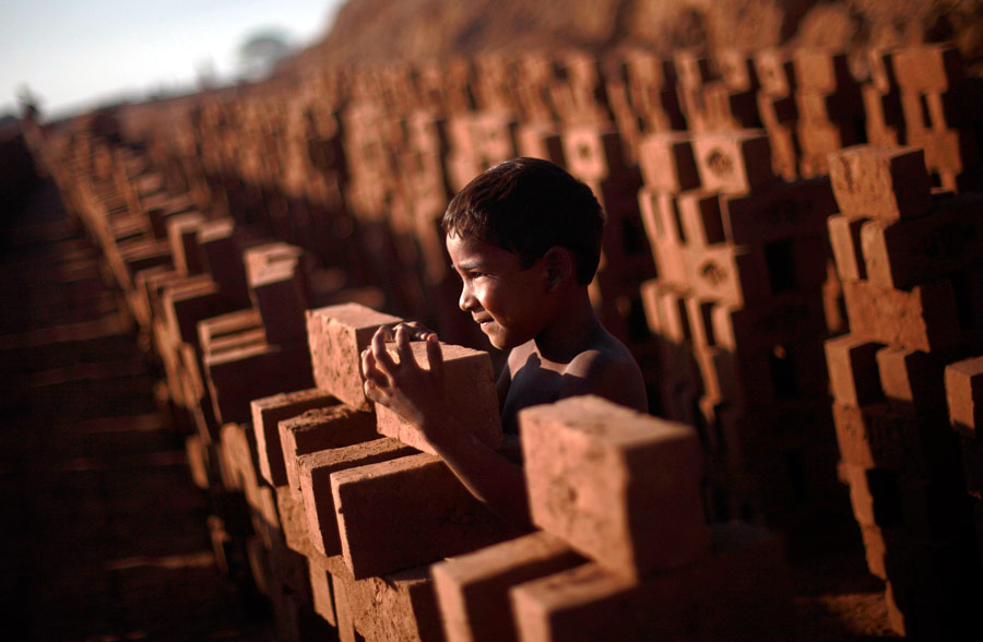 Пакистанский мальчик играет среди кирпичей на кирпичной фабрике на окраине Исламабада. © Nathalie Bardou/AP Photo