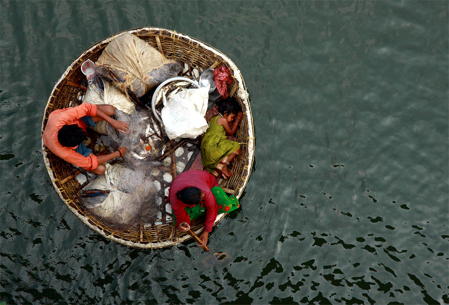 Семья рыбаков плывет в своей лодке по реке Перияр неподалеку от города Кочи в Индии. © Sivaram V/Reuters