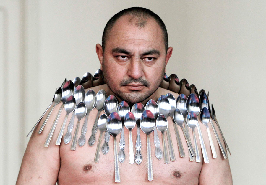 В Тбилиси Этибар Эльчиев устанавливает мировой рекорд. К его телу примагничено 50 металлических ложек. © David Mdzinarishvili/Reuters
